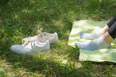 a person sitting on top of a blanket next to a pair of shoes